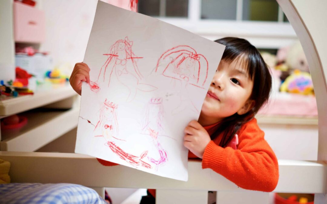 asian child holding artwork back to school safety tips